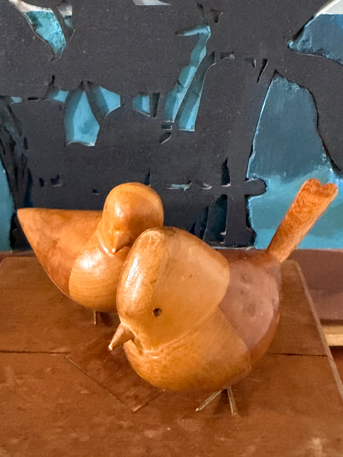 Two small carved wooden scandi retro birds with metallic wire legs.