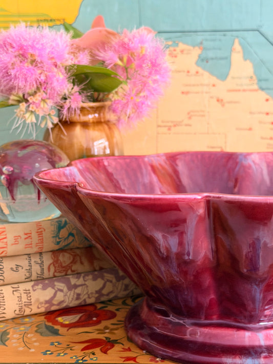A glossy marbled deep magenta-purple ceramic bowl with a fluted rim.