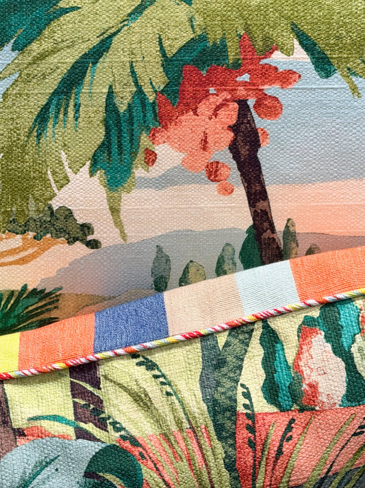 Close-up of a colorful fabric with tropical patterns and a branch.
