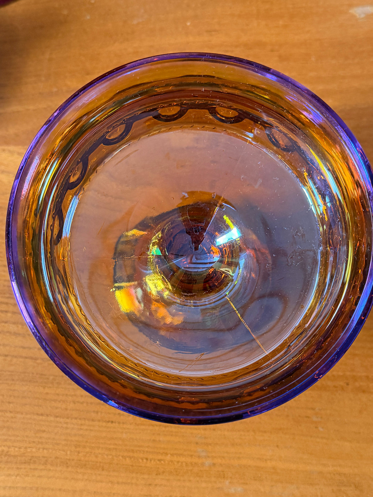 An iridescent carnival glass pedestal bowl , compote, with a gold-amber base and rainbow reflections, 