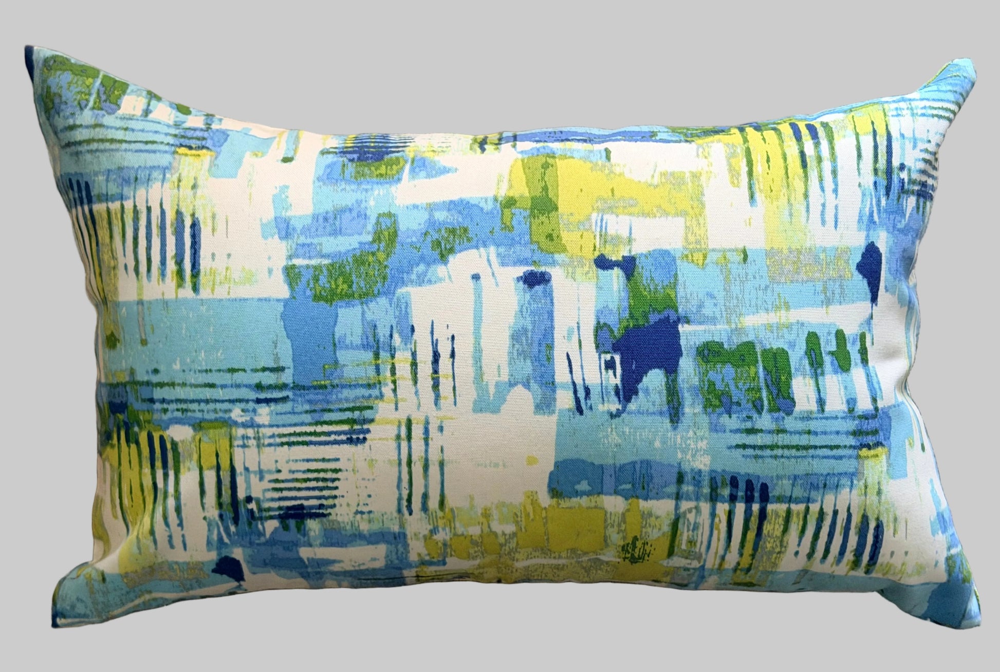 Decorative pillow with blue and green abstract pattern on a white backlground