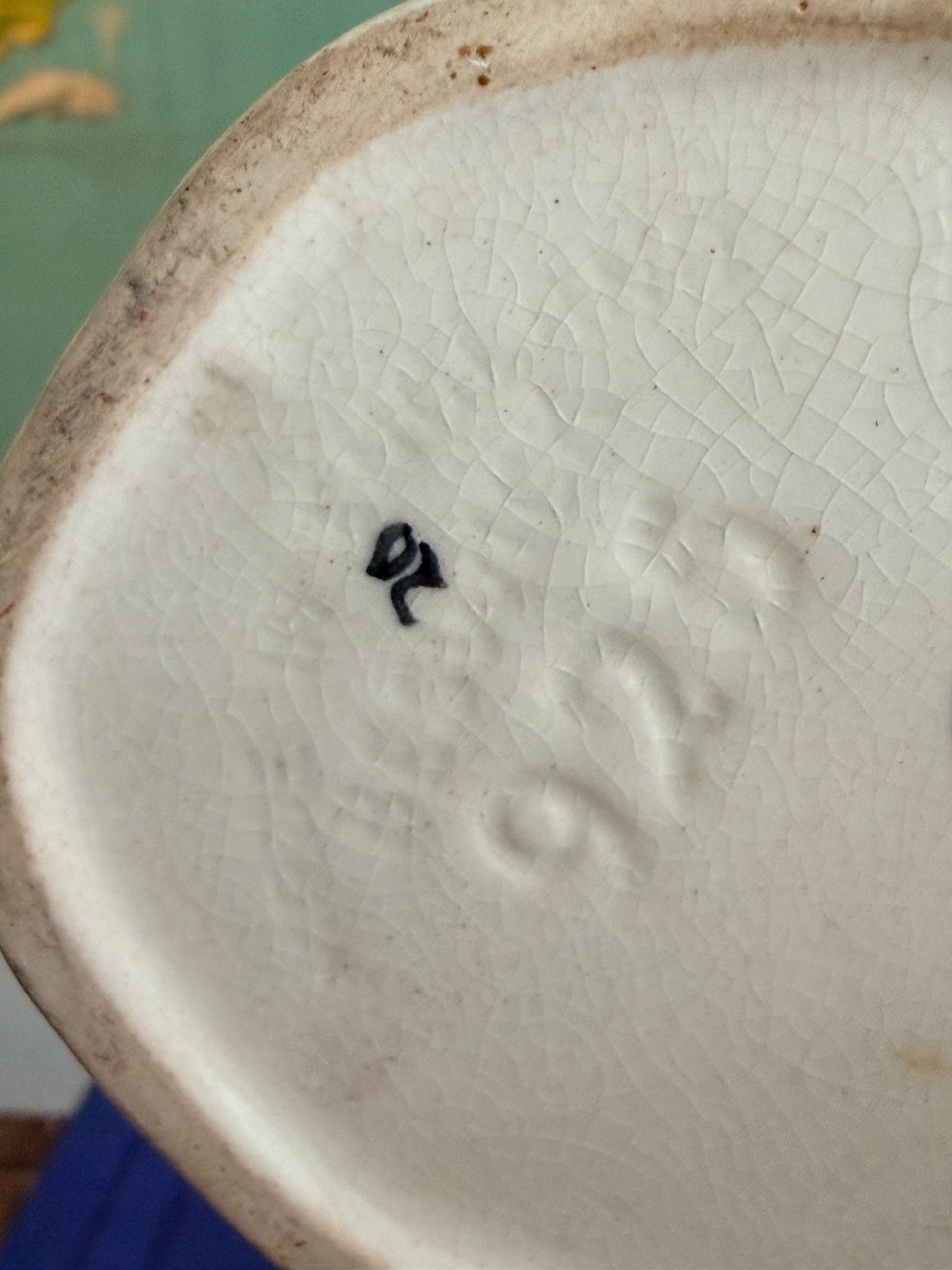 Close-up of a ceramic object with a visible brand logo on a blurred background