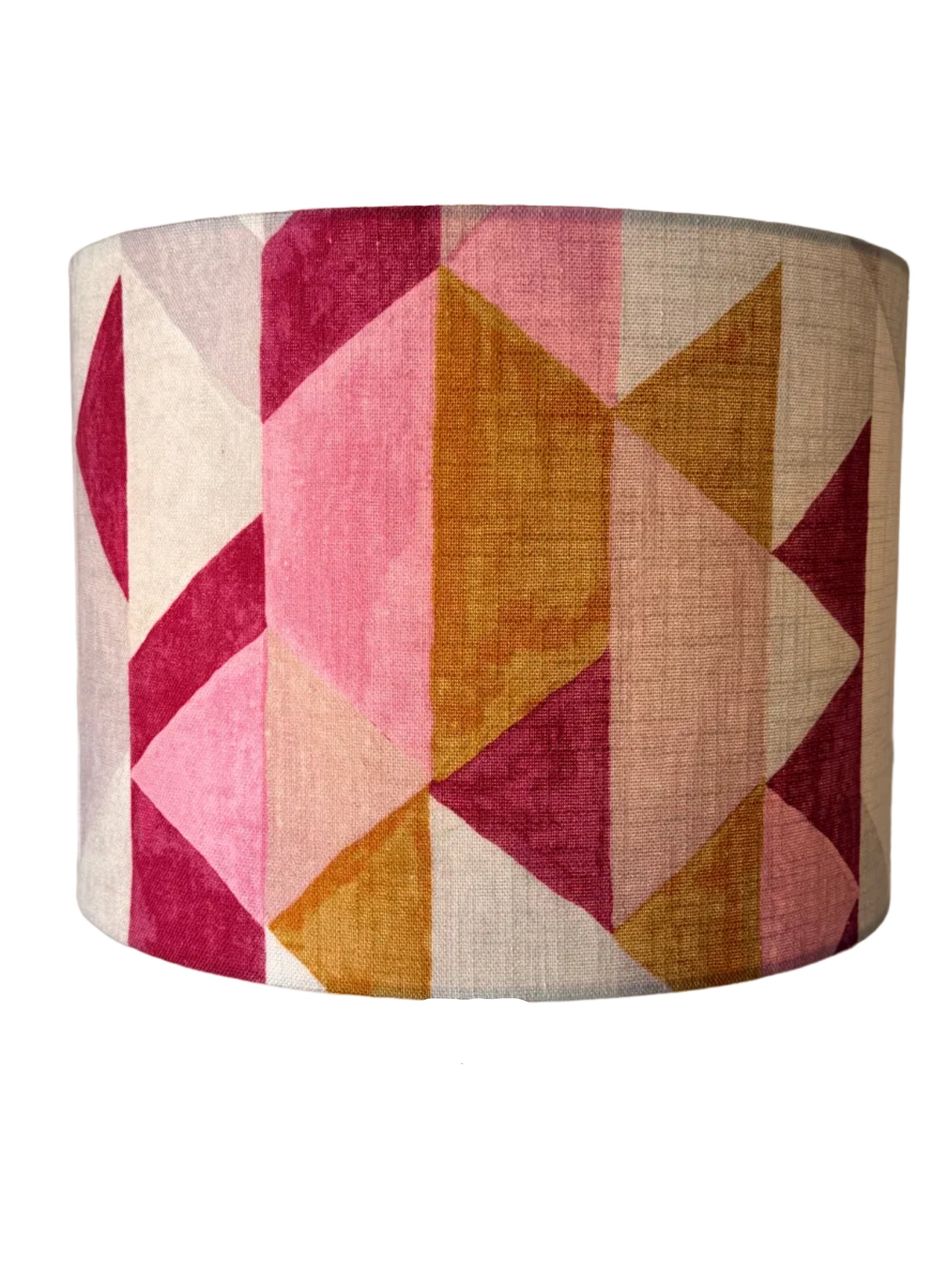 A lamp shade shade featuring a geometric pattern of pink, magenta, ochre, and beige triangles,
