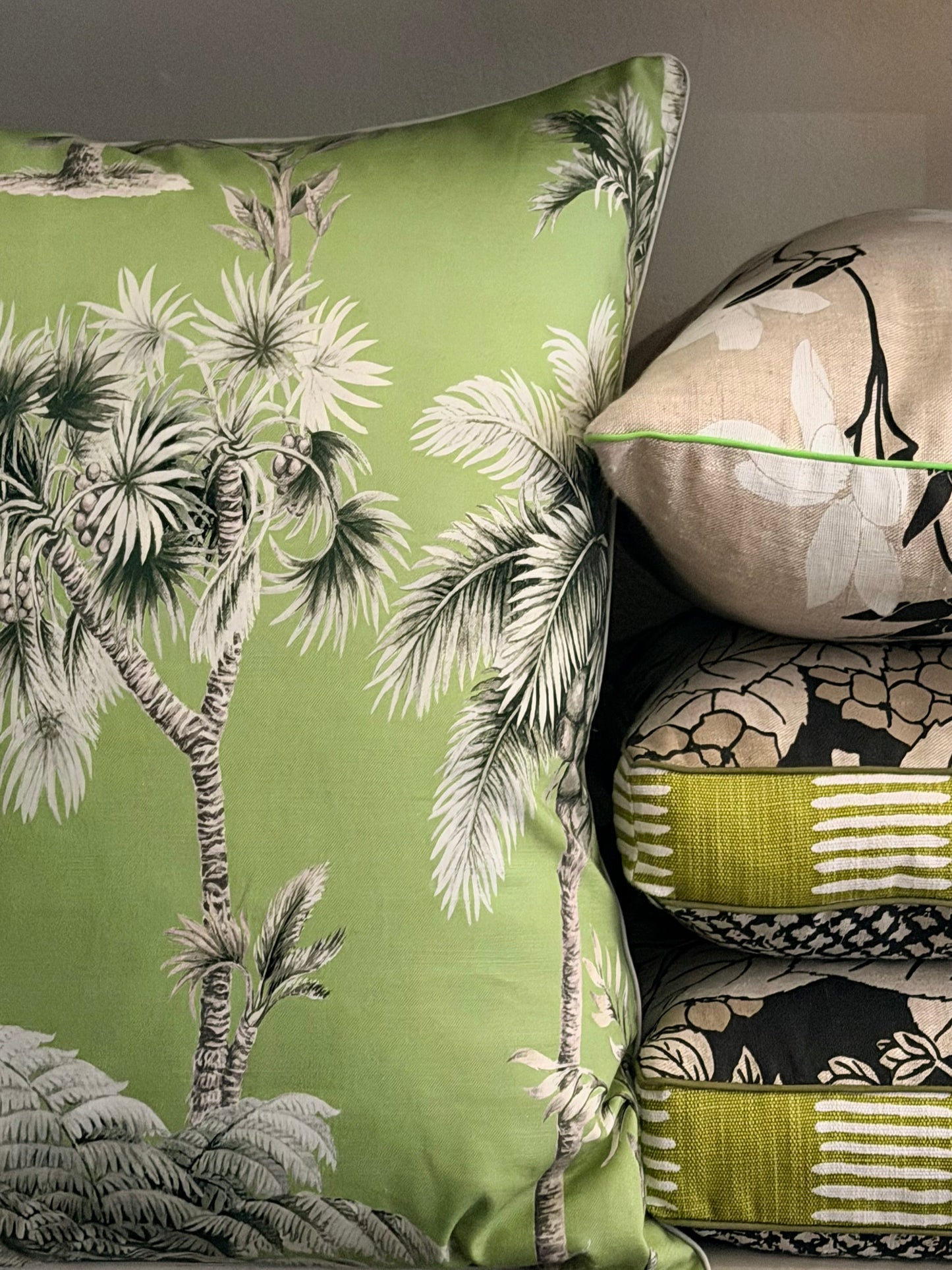 Decorative pillows with tropical tree design on a green background