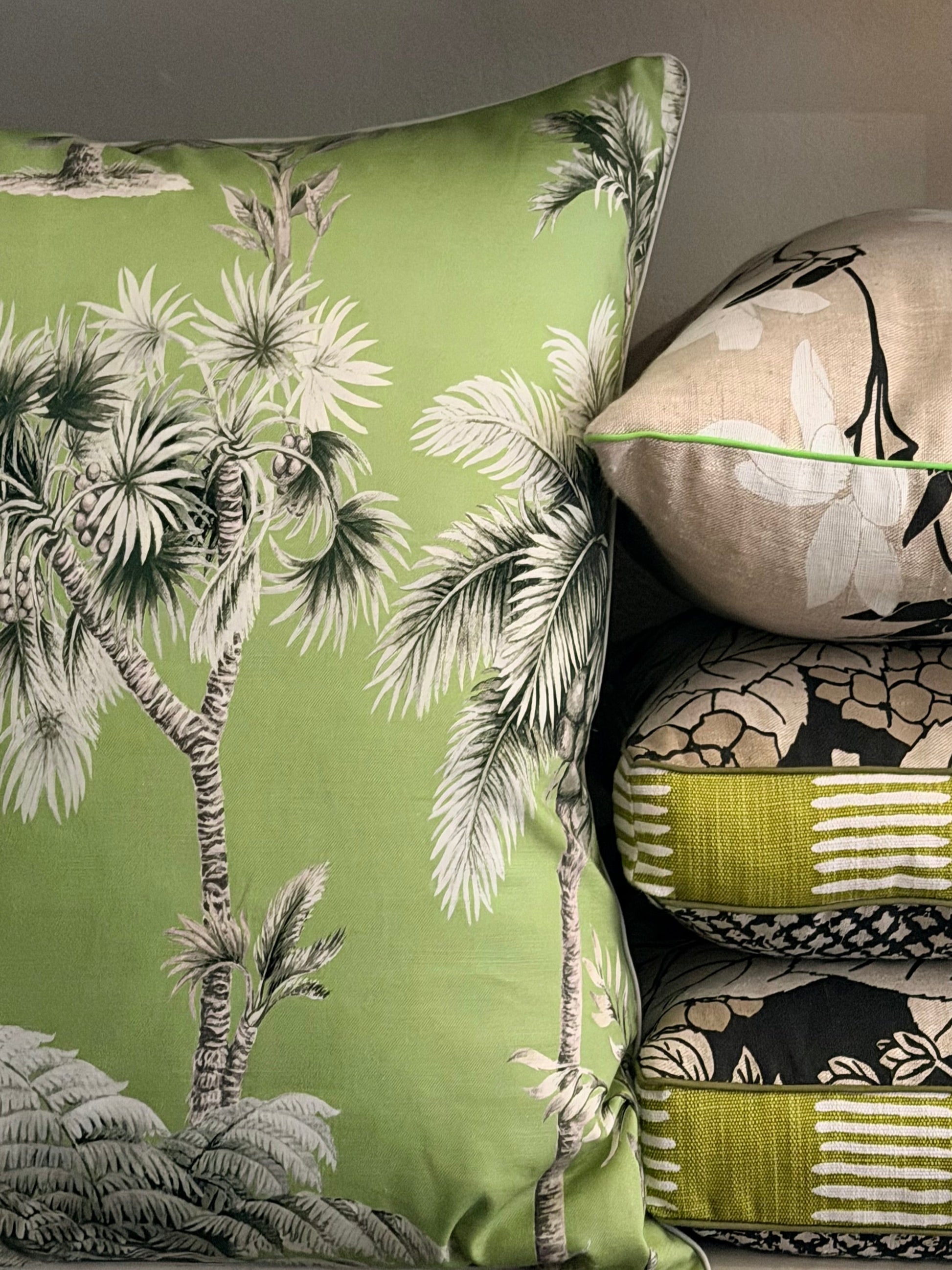 Decorative pillows with tropical tree design on a green background