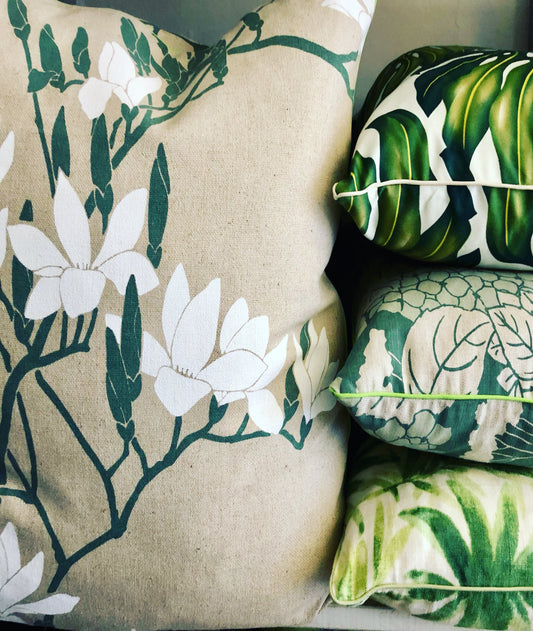 Set of decorative pillows with floral and leaf patterns on a neutral background