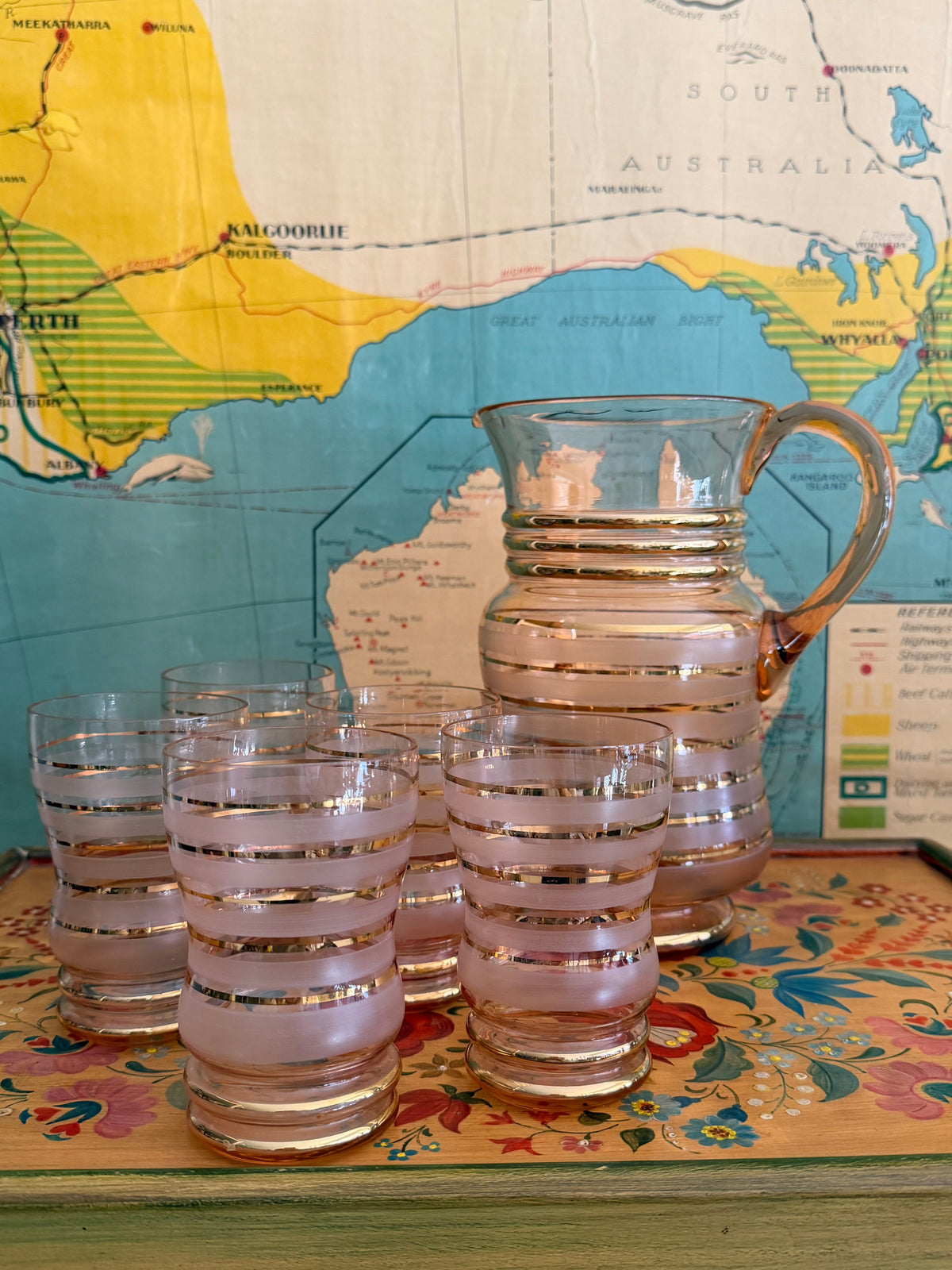 A group of retro vintage aqua blue glass tumblers with etched grape designs and bright blue bases,